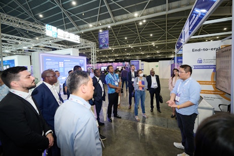 The AI Summit - Crowd gathers at a booth in the expo